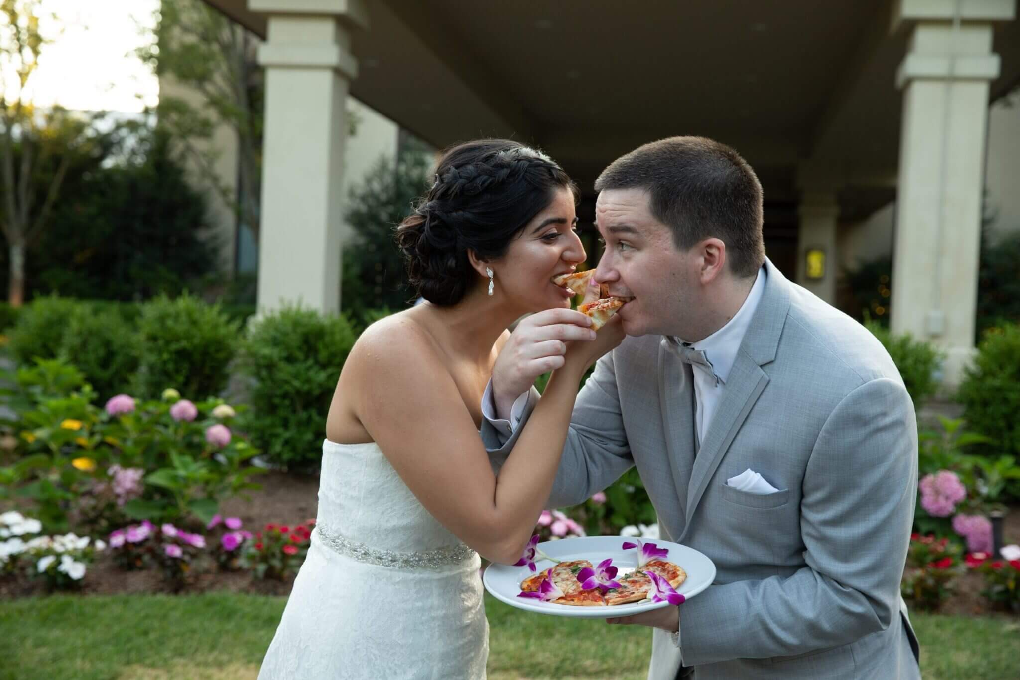 Bride and Groom feeding each other at an outdoor wedding reception in northern New Jersey