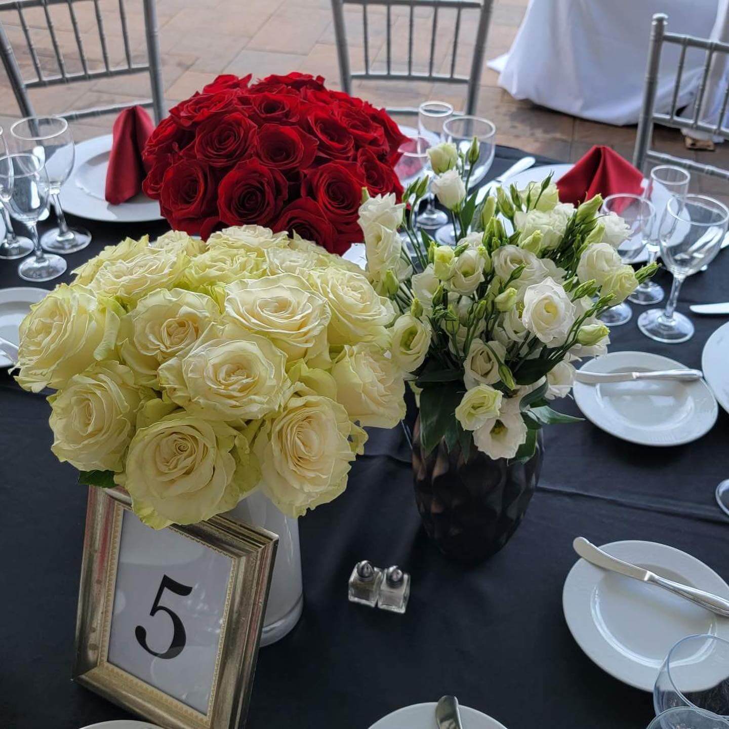 Close up of bouquets of roses atop a table at an outdoor event at Brookdale in New Jersey