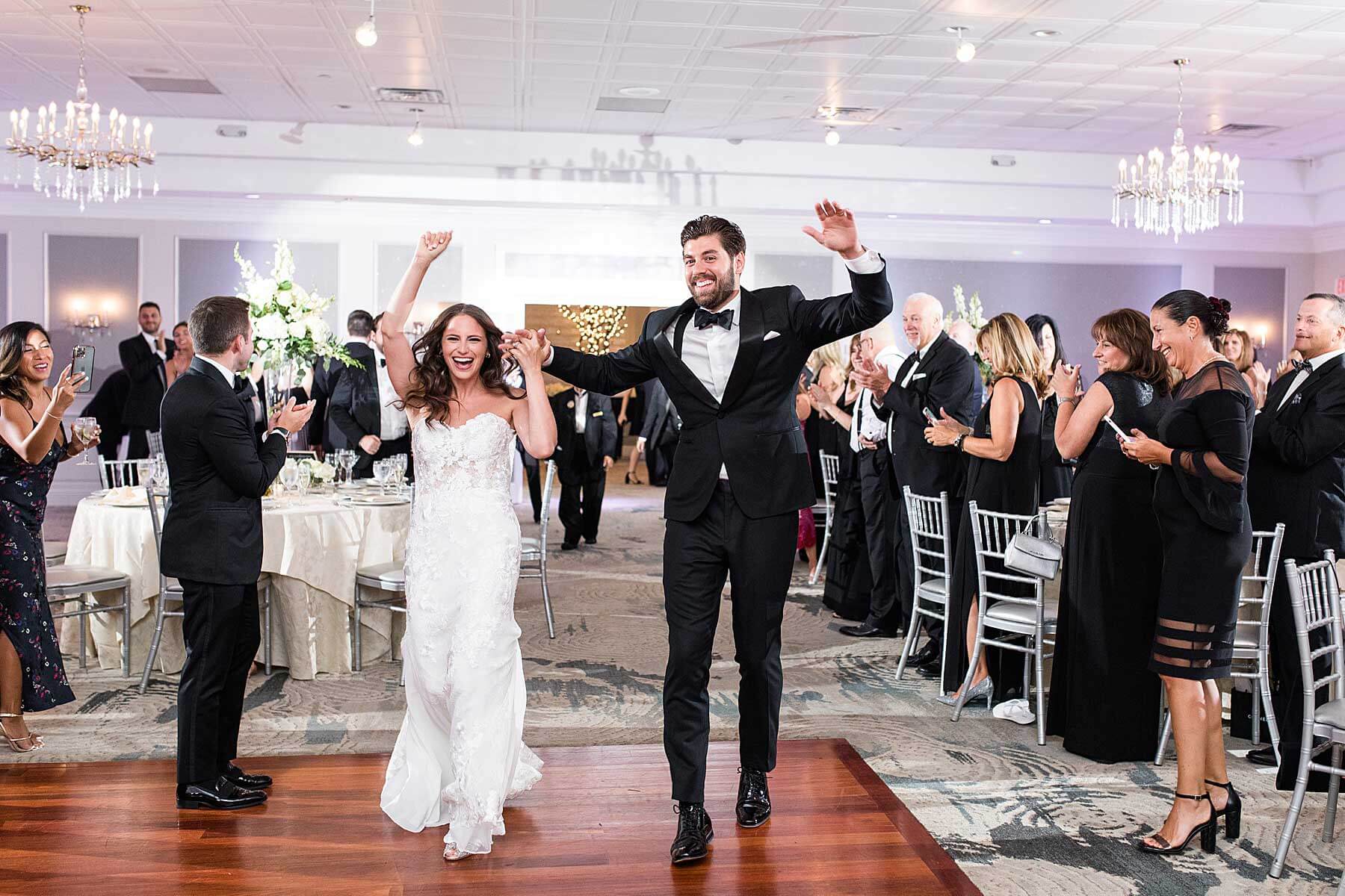 A bride and groom joyfully walk down the aisle at their outdoor wedding reception in one of the breathtaking New Jersey wedding venues.