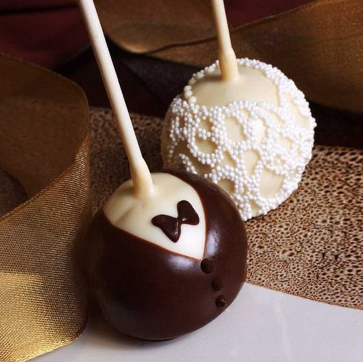Two chocolate cake pops with a bow tie on them at outdoor wedding venues in NJ.