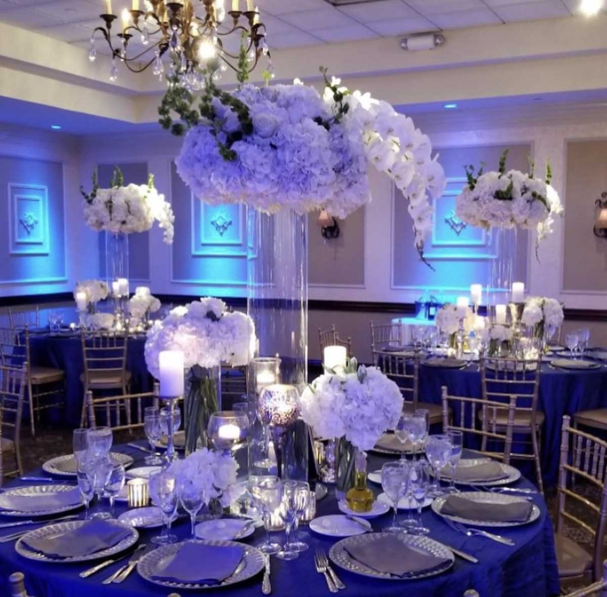 An enchanting blue and white wedding reception adorned with elegant centerpieces at one of the breathtaking outdoor wedding venues in NJ.
