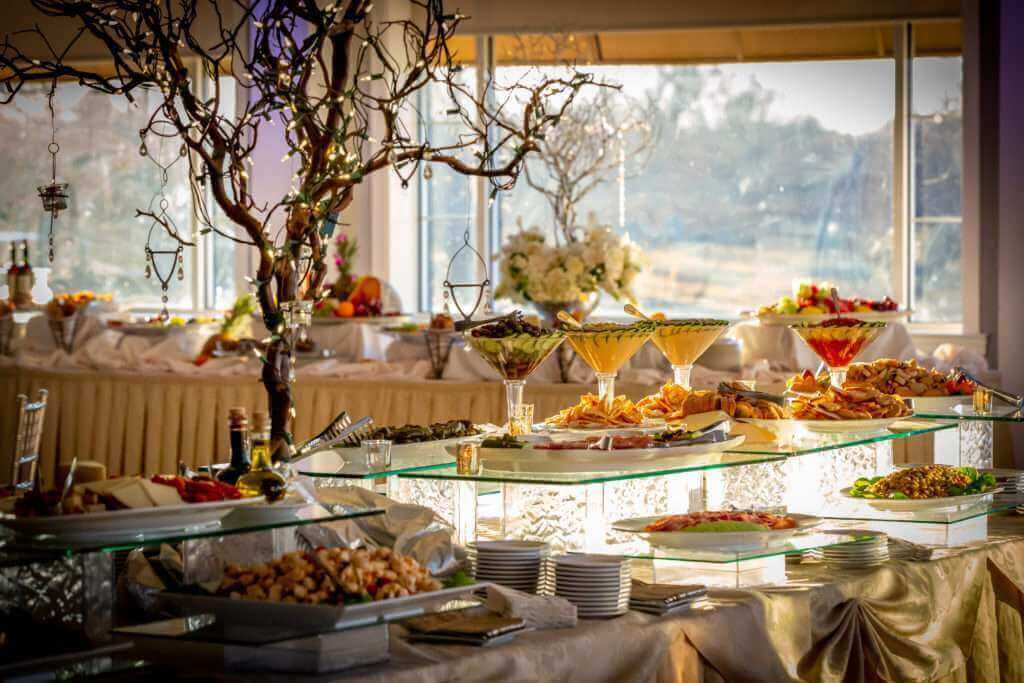 A lavish buffet table overflowing with delectable food, serving as the perfect inspiration for your wedding invitation ensemble.
